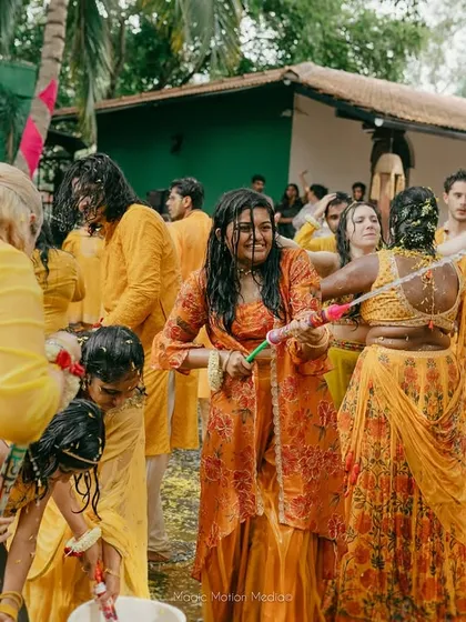 A playful water fight breaks out during the Haldi ceremony, filling our gardens with laughter and fun.