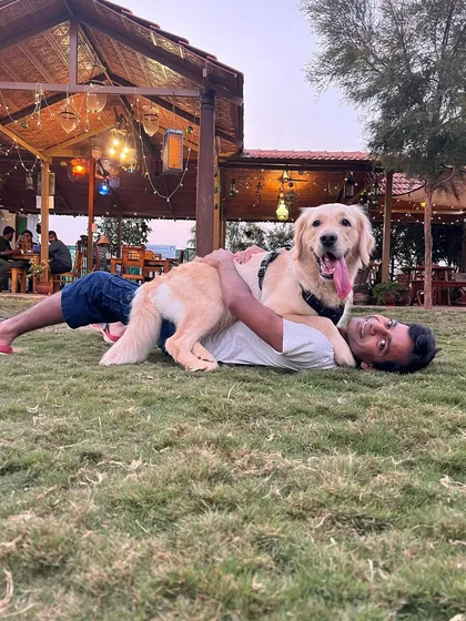It's all about the bond. This happy Golden Retriever enjoying a cuddle on our spacious lawn captures the relaxed, joyful atmosphere we cultivate at our ranch for both pets and their parents.