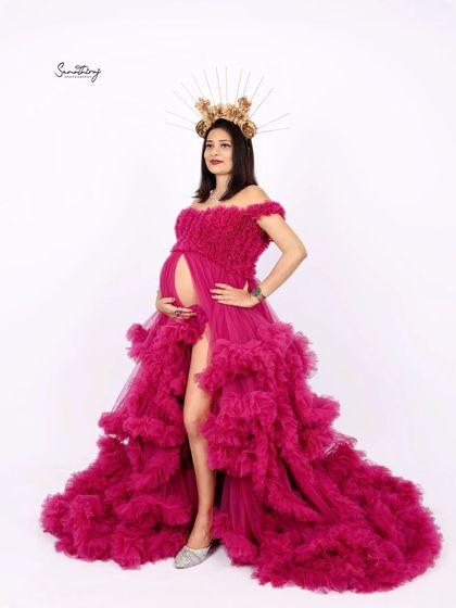 A powerful and regal portrait of a mother-to-be in a magenta gown, complete with a golden sunburst crown. This look is for the woman who wants to feel like a true queen.