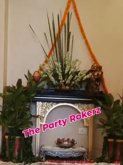 A home temple area decorated for Teej with fresh plants, floral arrangements, and marigold garlands.