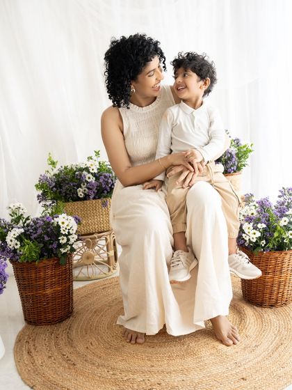 A tender moment between mother and son, sharing a look of love and affection in a beautiful, naturally lit setting.