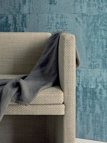 The 'Brumes Existentielles' wallpaper from Élitis captures the essence of artisanal craftsmanship. The textured design, which mimics coated raffia, is brought to life in a refreshing blue hue, adding a modern and artistic touch to the space.