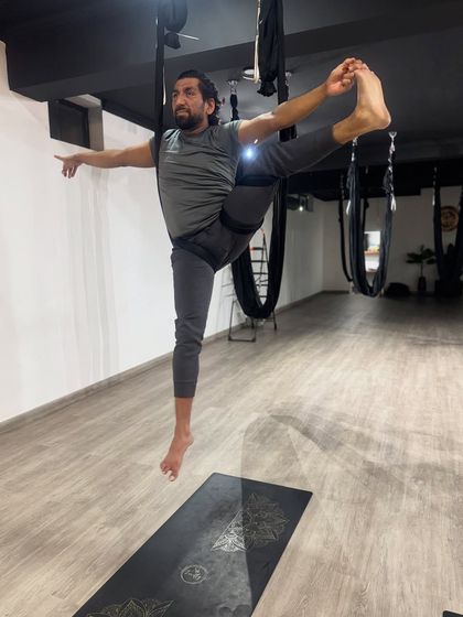 Floating in a supported hand-to-big-toe pose, this image showcases the balance, flexibility, and strength that our practice develops.