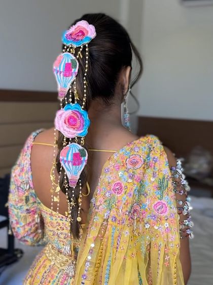 A whimsical and creative braid for a carnival-themed event. This style features a bubble braid adorned with unique hot-air balloon and floral accessories, making it a true conversation starter.