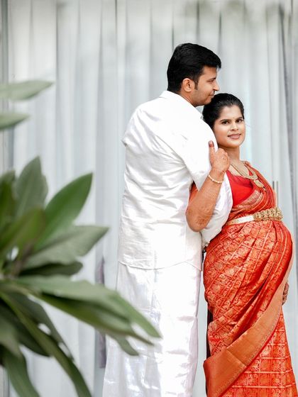 A loving pose from the couple during their indoor maternity session. The husband embraces his wife from behind, creating a portrait that is both elegant and full of affection.