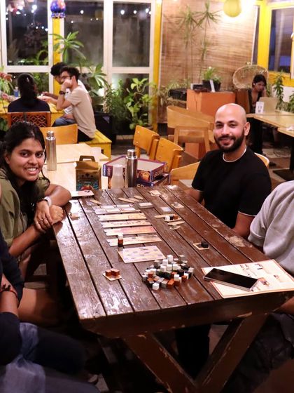Friends gathered for an evening of strategy and fun. Our rustic wooden tables have seen many epic board game battles.