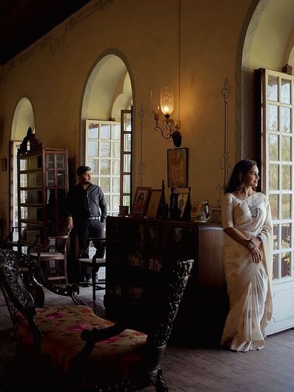 A wide shot inside a vintage-style room, capturing a sense of old-world charm. The natural light from the large windows creates a beautiful, moody atmosphere.