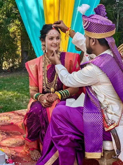 A sacred moment during the wedding rituals. The bride's traditional makeup, complete with a bindi and mundavalya, is perfectly suited for the cultural ceremony.