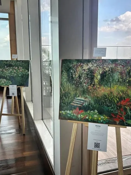 Impressionist paintings by Aleksandr Ibragimov on display at the Shangri-La Bengaluru, set against a stunning city view, as part of a collaborative event with 'Wine in a Million'.