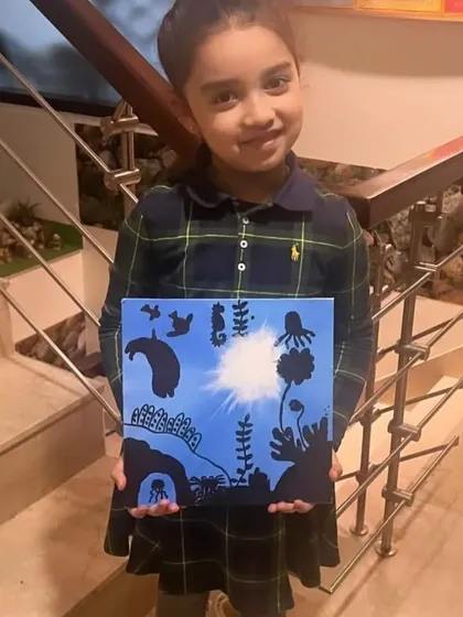 A proud young artist with her underwater silhouette painting. She did a wonderful job creating the sense of light shining down from the surface.