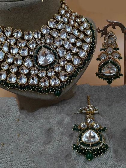 A close-up of a heavy Moissanite Polki necklace with a large central stone, paired with matching earrings.