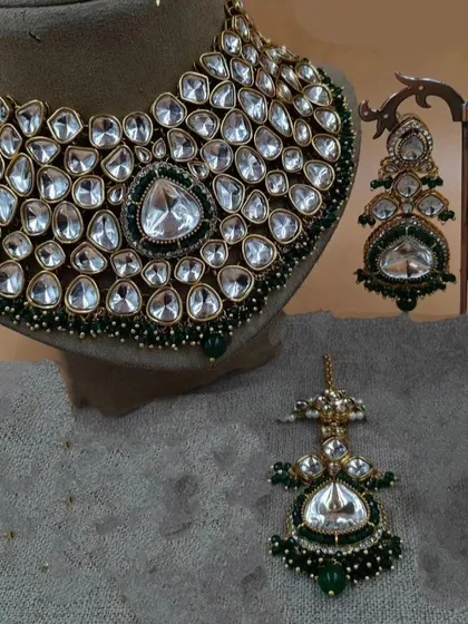 A close-up of a heavy Moissanite Polki necklace with a large central stone, paired with matching earrings.