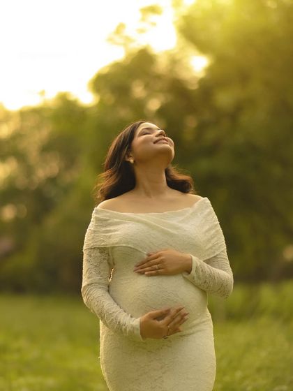Basking in the golden hour glow. This portrait of the mother-to-be in a white lace dress, looking up at the sun, is a simple yet powerful image of hope and radiance.