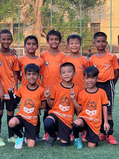 The victorious U7 team poses with their coaches after a great season.