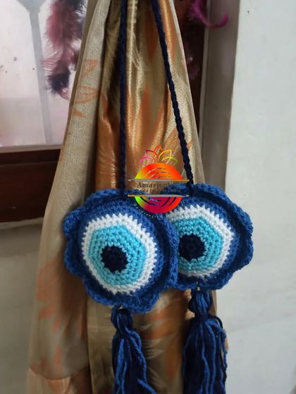 This curtain tie-back features the classic evil eye design, meant to bring good luck and protection. The blue and white design is finished with tassels for a bohemian look.