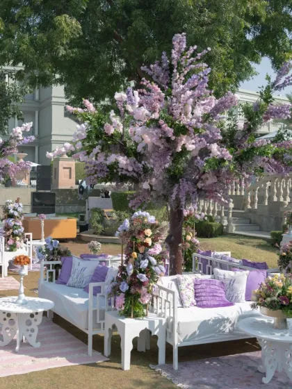 A serene lounge area under lavender-hued floral trees. I use color and florals to create distinct moods, transforming an outdoor space into a tranquil, fairytale-like setting.