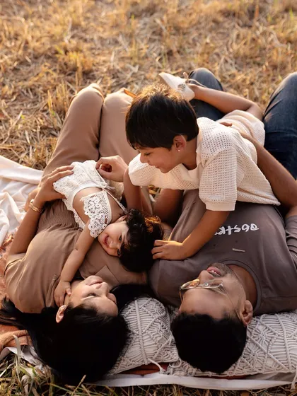 An outdoor family session isn't just about posing; it's about playing. This is a real family enjoying a beautiful day, with their two kids, captured in the warm evening light. These are the candid, joyful memories you'll look back on for years.