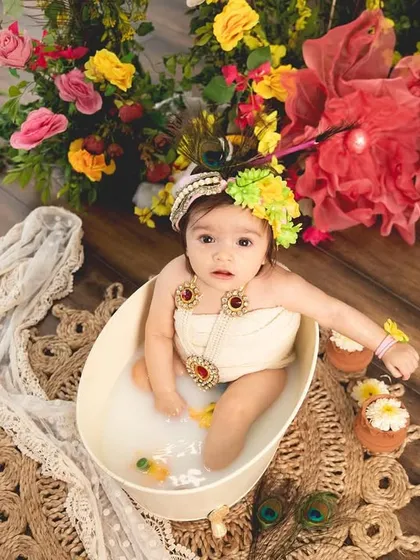 An overhead view of the Radha-themed milk bath, surrounded by colorful flowers. This perspective shows the beauty and detail of the entire setup.