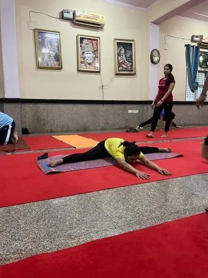 A student achieves a full split, or Hanumanasana, in our class. This level of flexibility is the result of patience, dedication, and proper technique.
