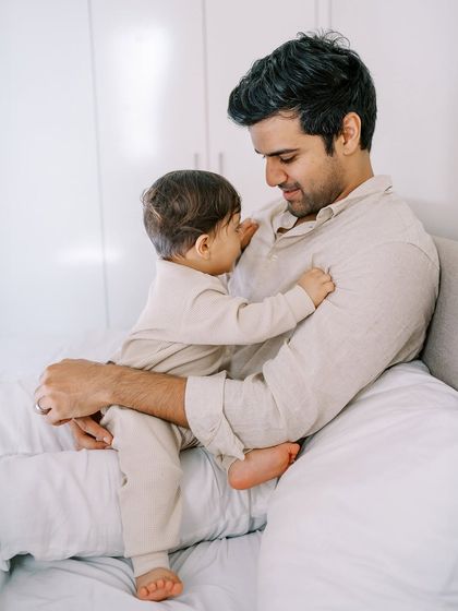 A father and son sharing a quiet cuddle on the bed. These tender moments are just as important as the loud, playful ones.