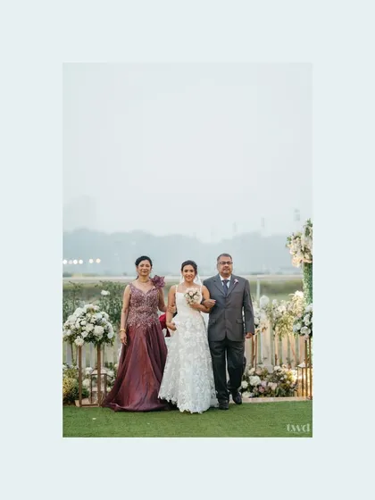 A classic photo of the bride walking down the aisle with her mother and father. A proud and emotional moment for the entire family.