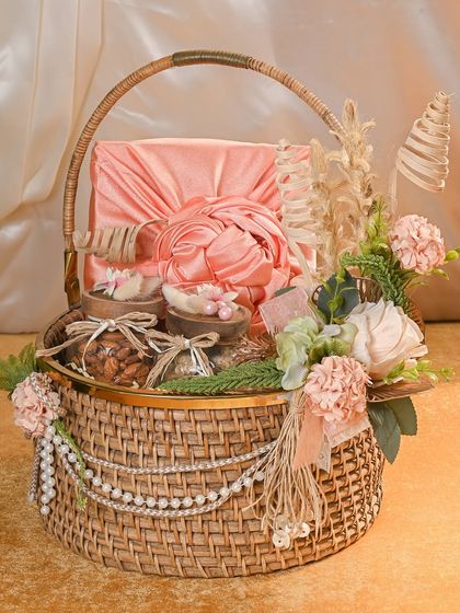 This elegant cane basket hamper is one of my most popular Rakhi gifts. It's adorned with pearls and florals and filled with jars of dry fruits and a beautifully wrapped gift box, perfect for your sister.