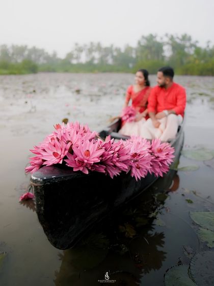 A wide shot showing the boat adorned with flowers, creating a stunning visual on the calm water.
