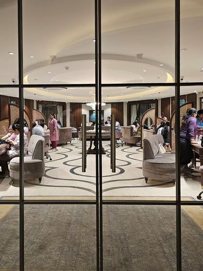 A view through the glass doors at KR Sons reveals the store's unique layout. The curved seating and patterned floor guide the eye, while the arrangement of private consultation areas is visible, showcasing a design that balances openness and intimacy.