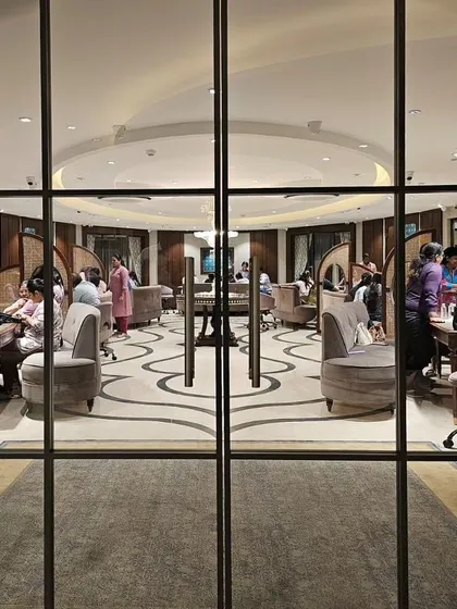 A view through the glass doors at KR Sons reveals the store's unique layout. The curved seating and patterned floor guide the eye, while the arrangement of private consultation areas is visible, showcasing a design that balances openness and intimacy.