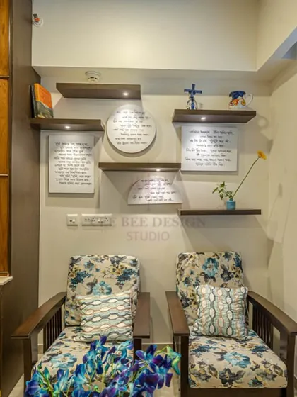 A close-up of the reading nook from image 3, showing the floral chairs and framed manuscripts.