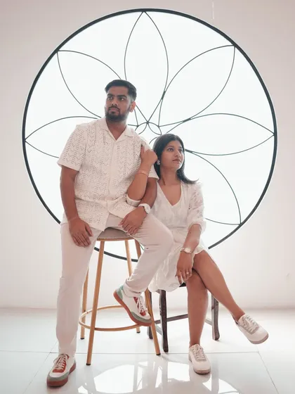 A stylish, high-fashion pose against a minimalist white backdrop with an artistic floral motif. This shot is perfect for couples who want a modern and artistic feel for their pre-wedding photos.