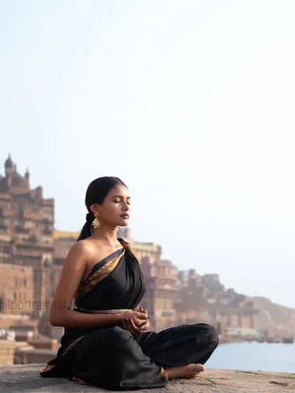Where the soul breathes and time stands still. A woman meditates by the Ganga, embodying the spiritual tranquility that defines Varanasi.