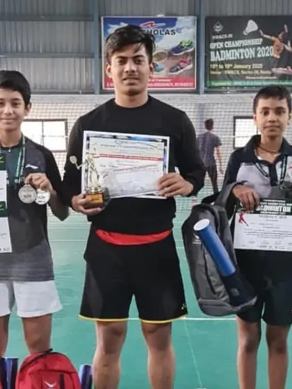 A photo from a newspaper feature, showing our coach with some of our champion players and their certificates after a successful tournament.