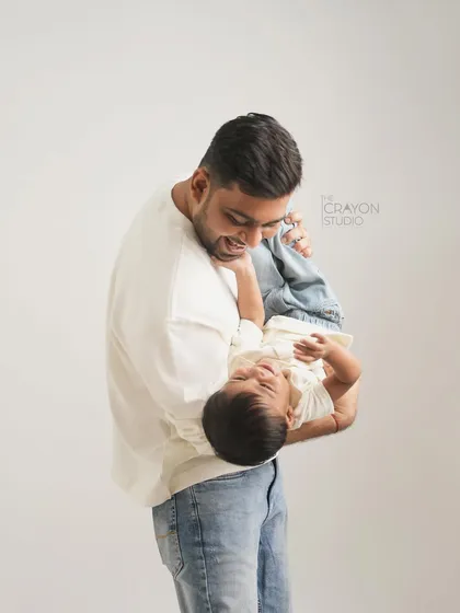 A moment of playful fun, captured forever. A father holds his son upside down, and the resulting laughter makes for a wonderfully authentic and joyful studio portrait.