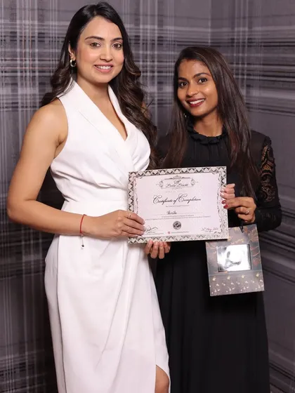 Another student proudly holding her certificate. She is now ready to start her journey as a makeup artist.