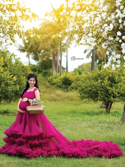 A beautiful outdoor portrait in a wine-colored ruffled gown. The long train and the natural setting create a stunning image.