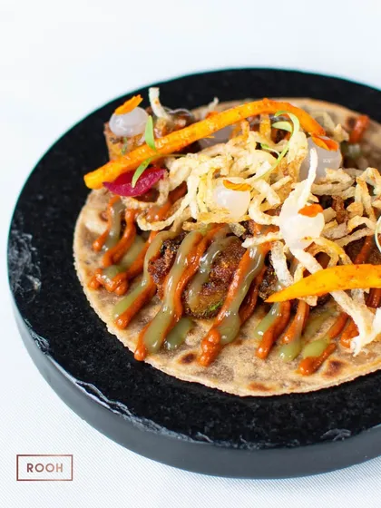 A beautifully plated taco with Heeng Achar Kalhare Aloo. The crispy potato straws on top add a wonderful textural contrast to the dish.