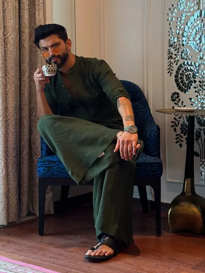 Enjoying a cup of tea in my olive green outfit. Even in my downtime, I like to keep it stylish.