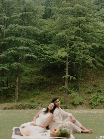 A romantic picnic scene with the couple relaxing in a meadow in Mussoorie.