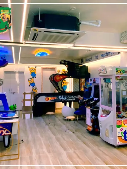 A view of the arcade featuring a basketball game and a claw machine, with fun Minion decorations on the wall.