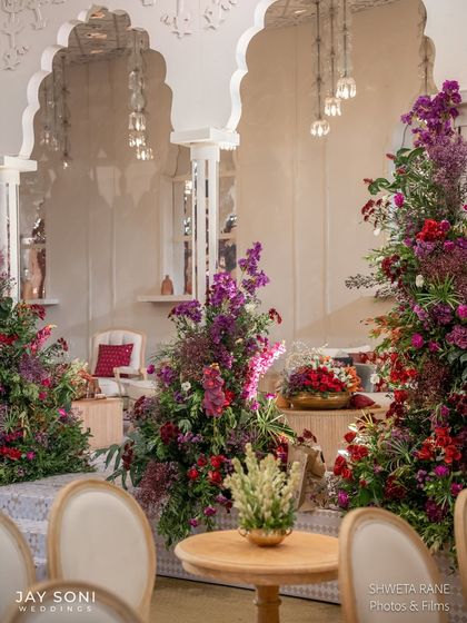 A closer look at the lounge, showing how the vibrant floral arrangements contrast beautifully with the neutral tones of the furniture and the intricate white architectural details.