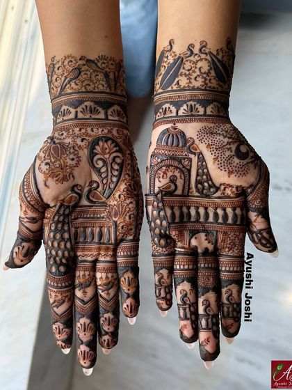 An intricate Indian design for the groom's family, with one hand featuring a majestic elephant and the other a graceful peacock.