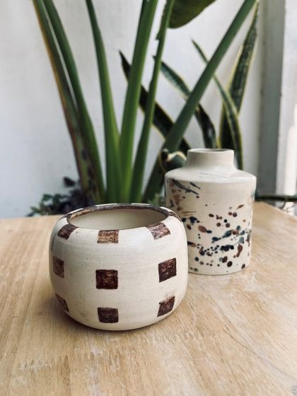 A checkered pot and a splatter-glazed vase, showcasing two very different but equally beautiful decoration styles.
