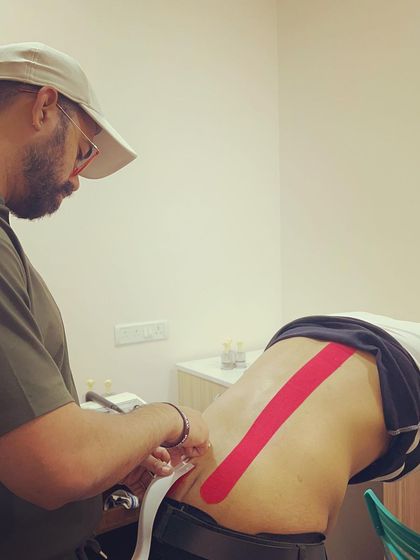 Finalizing the application of kinesio tape. This technique is a valuable part of our toolkit for managing acute pain and supporting clients during their recovery.