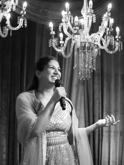A classic black and white portrait of me hosting under elegant chandeliers. It shows the sophisticated and formal side of my anchoring style.