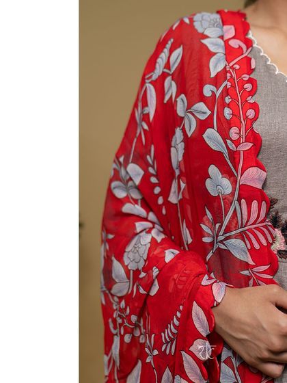 The contrast between the mud brown dress and the bright red printed dupatta creates a bold and stylish statement.