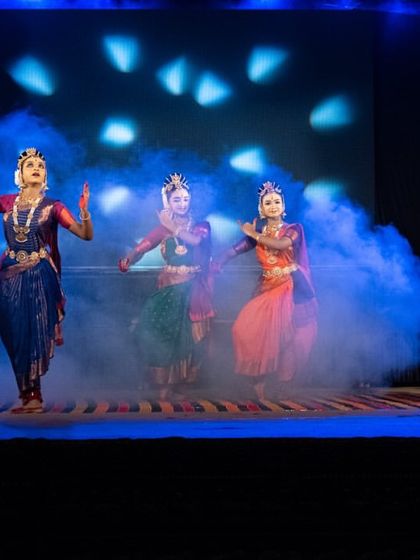 Dancers perform on a smoke-filled stage, adding to the drama and atmosphere of the "KRISHNA" production. The lighting design is crucial in setting the mood for each scene.