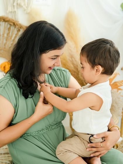 A quiet moment of connection between mother and child. Her gentle touch and his focus create a serene and loving portrait.