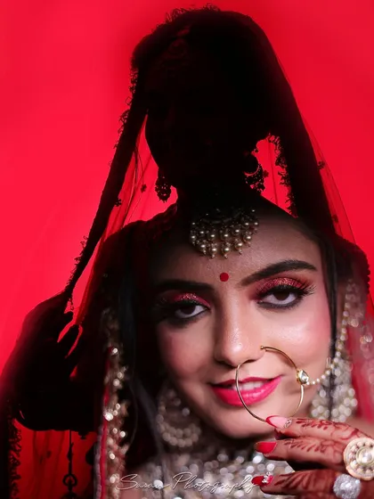 A striking bridal portrait with a red background, where the bride's silhouette is used to create a powerful artistic effect.