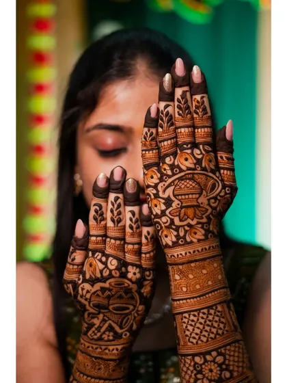 A close-up of the bride's hands, showcasing the detailed patterns of her traditional mehendi. I always make sure to capture the artistry of the henna.